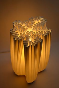 an intricately designed vase is lit by the light coming from it's base