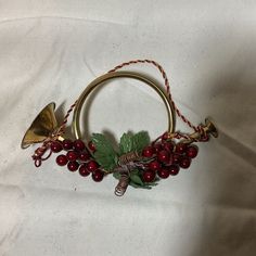 a christmas wreath with bells and holly leaves on white fabric background for use as an ornament