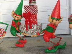 three garden gnomes with gifts in front of a garage door