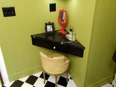 a bathroom with green walls and checkered flooring on the floor is decorated in black and white