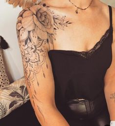 a woman with tattoos on her arm and shoulder