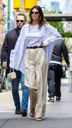 a woman walking down the street with her hands in her pockets