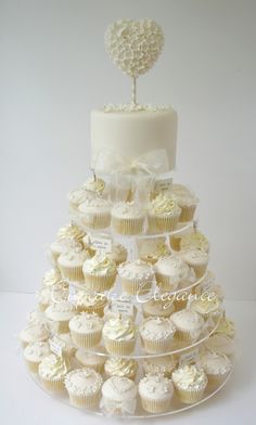 a tiered cake with cupcakes on it