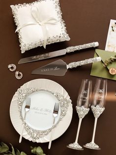 a table topped with white plates and silverware next to a napkin, fork and knife