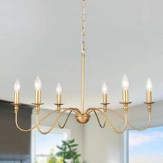 a chandelier with six lights hanging from the ceiling in a dining room area