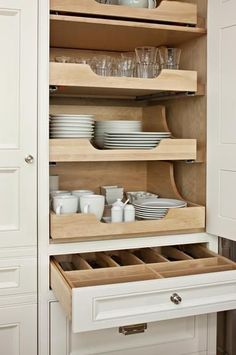 an open cabinet with plates and cups in it