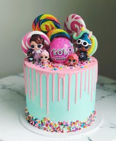 there is a cake decorated with lol surprisers and candy on the top layer