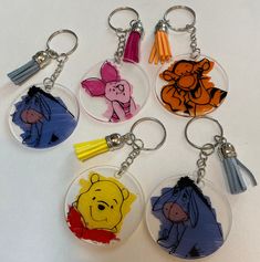 four winnie the pooh keychains are shown with different colors and designs on them