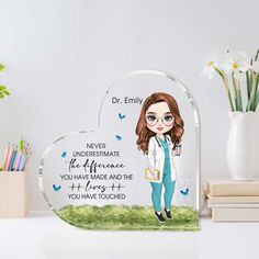 a personalized glass heart shaped plaque with a cartoon girl holding a book and pencils