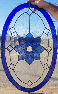 a hand holding up a stained glass flower