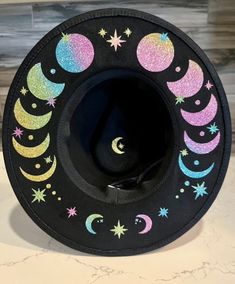 A sturdy thick 100% polyester hat. I have applied glitter rainbow moon phases and stars. Get your witchy vibe on. It has adjuster inside. Size M/L Circumference 22.8 inches 4 inch brim Moon Hat, Custom Cowboy Hats, Witch Moon, Glitter Rainbow, Painted Hats, Witchy Fashion, Wide Brim Fedora, Stacked Necklaces, Future Style