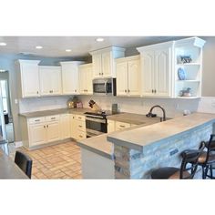 a kitchen with white cabinets and counter tops