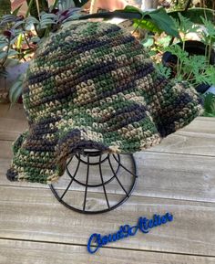 a crocheted hat sitting on top of a metal stand