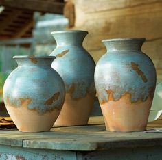 three vases sitting on top of a wooden table