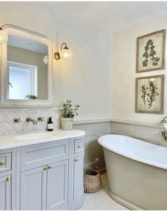 a white bath tub sitting under a bathroom mirror