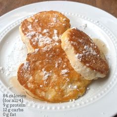 two pancakes on a white plate covered in powdered sugar