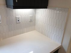 a white counter top sitting under a light switch