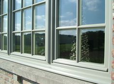 there is a small christmas tree in the window sill on this brick building,