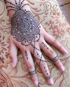 a woman's hand with hennap on it and some beads around the wrist