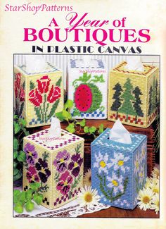 the cover of a cross stitch book with four small boxes and flowers on each side