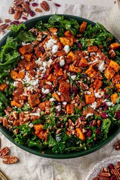 a salad in a bowl with pecans on the side