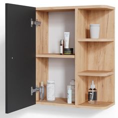 an open wooden cabinet with various items on the shelves and in between it is a black door