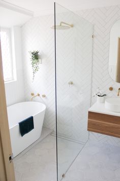 a bathroom with a glass shower door, sink and bathtub