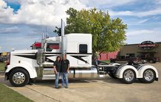 two men standing in front of a semi truck