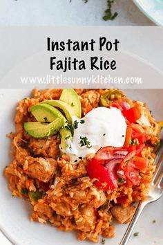 a white plate topped with rice covered in avocado and tomatoes next to a fork