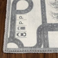 a close up of a rug on a wooden floor with an image of a road