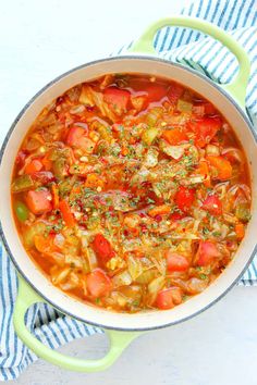 a pot filled with vegetable soup on top of a blue and white towel