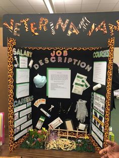 a bulletin board with writing on it and various items attached to the board, in front of a classroom wall