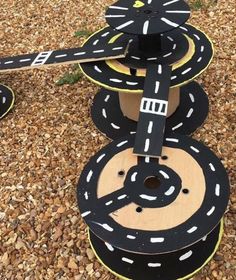 three cardboard cars stacked on top of each other in the shape of a road with white markings