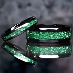 two wedding bands with green glitter on them