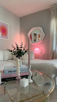 a living room filled with furniture and a glass coffee table in front of a mirror