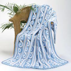 a blue and white blanket sitting next to a potted plant