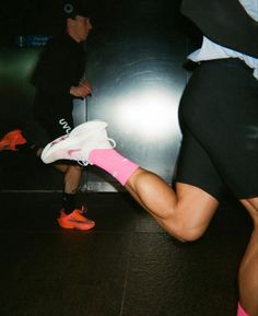 the legs and feet of two people in running gear, one is wearing pink socks