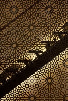 an intricately designed ceiling in the middle of a building with light coming through it