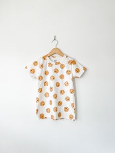 You little one will love our smiley face print t shirt! Not only is it super soft, it's also made out of 100% organic cotton. We flare out the sides a little bit for a looser, modern fit.  Pair it with our smiley face romper for a sibling matching moment!  F A B R I C  This adorable shirt features cotton produced in the USA that is certified organic by global organic textile standards so you can feel good about dressing your baby or toddler in it!  We serge all seams for added durability and str Playful White T-shirt With Smiley Face, Playful Organic Cotton Tops For Playwear, Playful White T-shirt For Everyday, Playful White T-shirt For Loungewear, Smiley Face Top For Loungewear, Relaxed Fit Smiley Face Top For Loungewear, Playful Organic Cotton Tops For Everyday, Playful Everyday Organic Cotton Tops, Cute Cotton Tops With Smiley Face