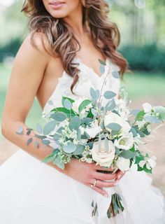 the bride is holding her bouquet and posing for an instagramt photo on her wedding day