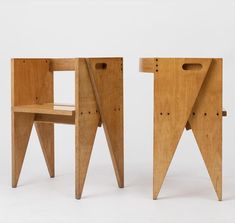 two wooden chairs sitting next to each other on top of a white surface with holes in them