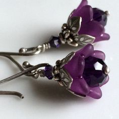 "Adorable and sweettiny amethyst tulips from my \"Bouquet of Flowers\" collection These precious little tulips are designed from dark amethyst colored Swarovski crystals capped with beautiful acrylic tulips. Layers of ornate leafy beadcaps in antique sterling silver plate add that perfect touch of detail. These diminutive drops hang a mere 5/8\" (14mm) from oxidized sterling silver French earwires. Prefer a different style of earwires? Non pierced clips in antique silver plate, leverbacks and ki Purple Dangle Flower Earrings, Purple Nickel-free Drop Flower Earrings, Crystal Winter, Adjustable Amethyst Crystal Earrings, Elegant Style, Purple Flower-shaped Earrings, Winter Wedding Bridesmaids, Spring Flower-shaped Purple Earrings, Dark Amethyst, Amethyst Flower