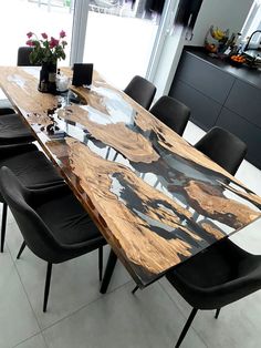 a wooden table with black chairs around it