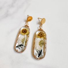 the dandelion earrings are made with glass and gold