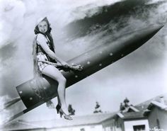 an old photo of a woman sitting on top of a large jetliner in the air