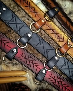 leather dog collars lined up on top of each other in different colors and patterns