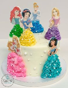 there is a cake decorated with princesses on the top and bottom tiers in different colors