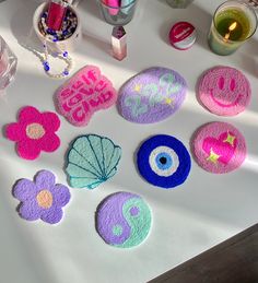 several bath mats with different designs on them sitting on a table next to candles and other items