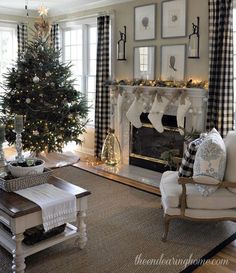 a living room filled with furniture and a christmas tree in front of a fire place