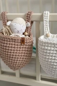 two baskets with stuffed animals in them hanging from the side of a crib,